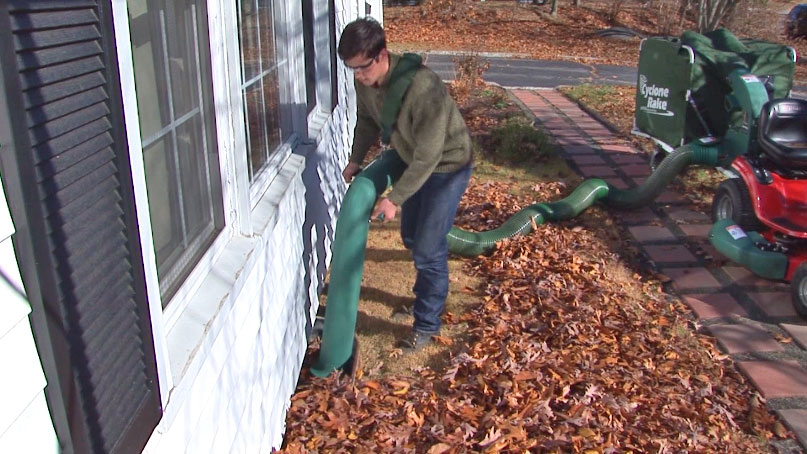 man using hose from cyclone lawn tractor 