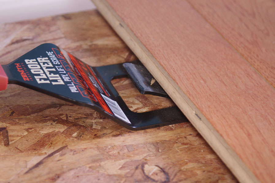 Man using Zenith Industries Floor Lifter to remove wooden flooring 