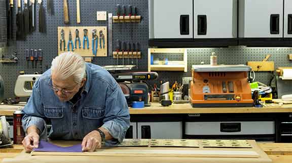 Man glues sandpaper to make non slip surface 