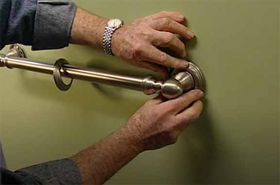 Man installs bathroom grab bar
