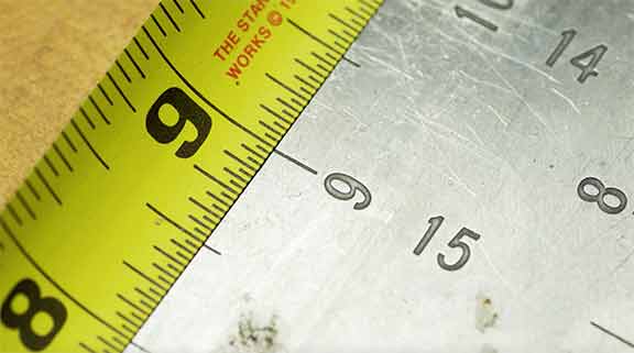Man looking at accurate marking on tape measure