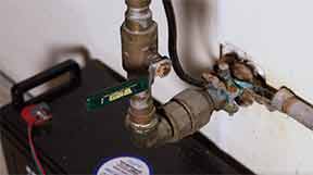 Man turning off household water supply