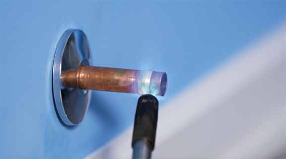 Man using heat to loosen compression ring