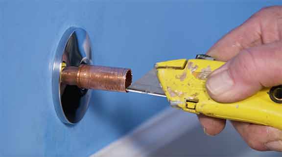 Man using utility knife to utility knife to remove burrs