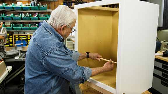 Man using wooden sticks to measure