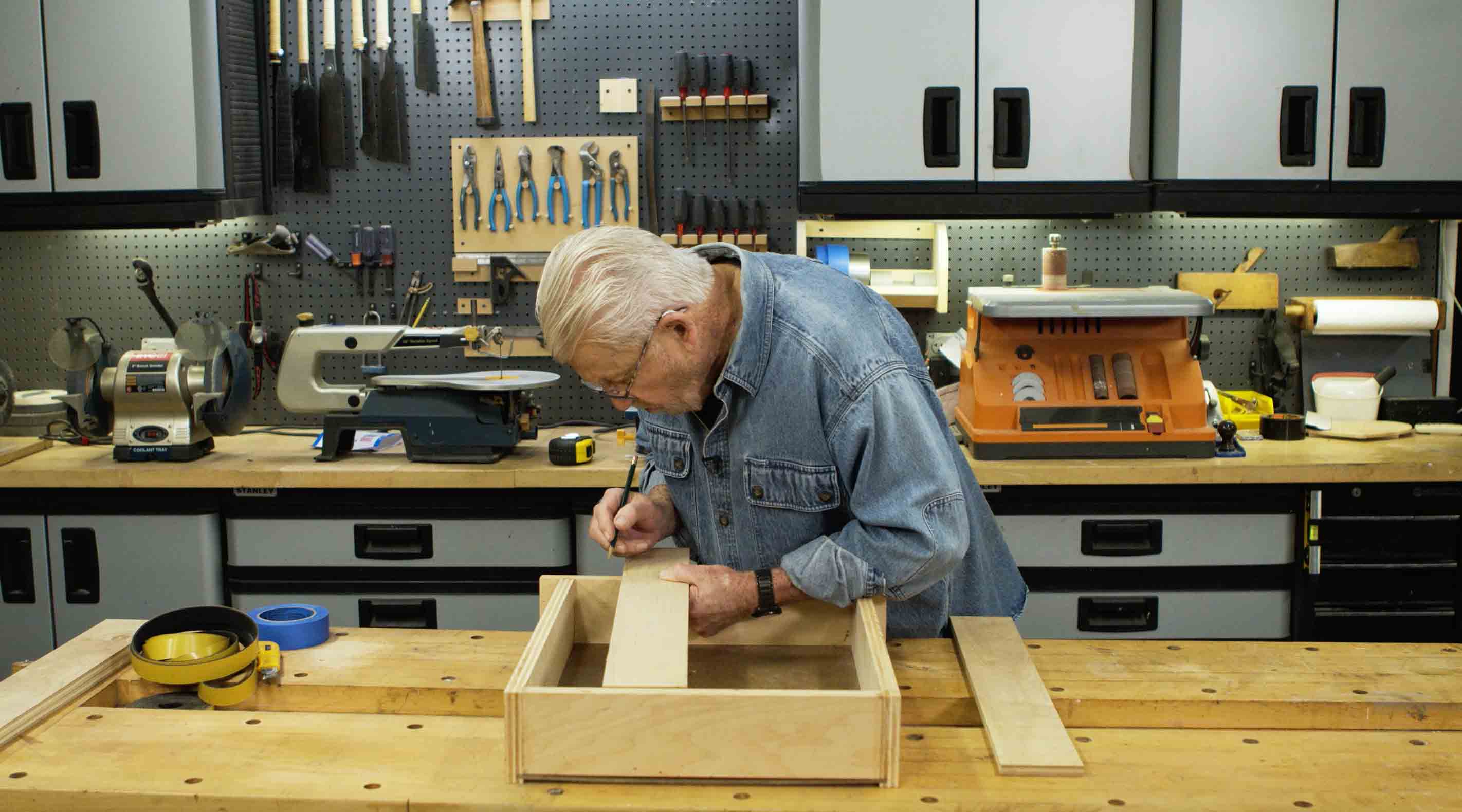 Man marks drawer divider for cutting