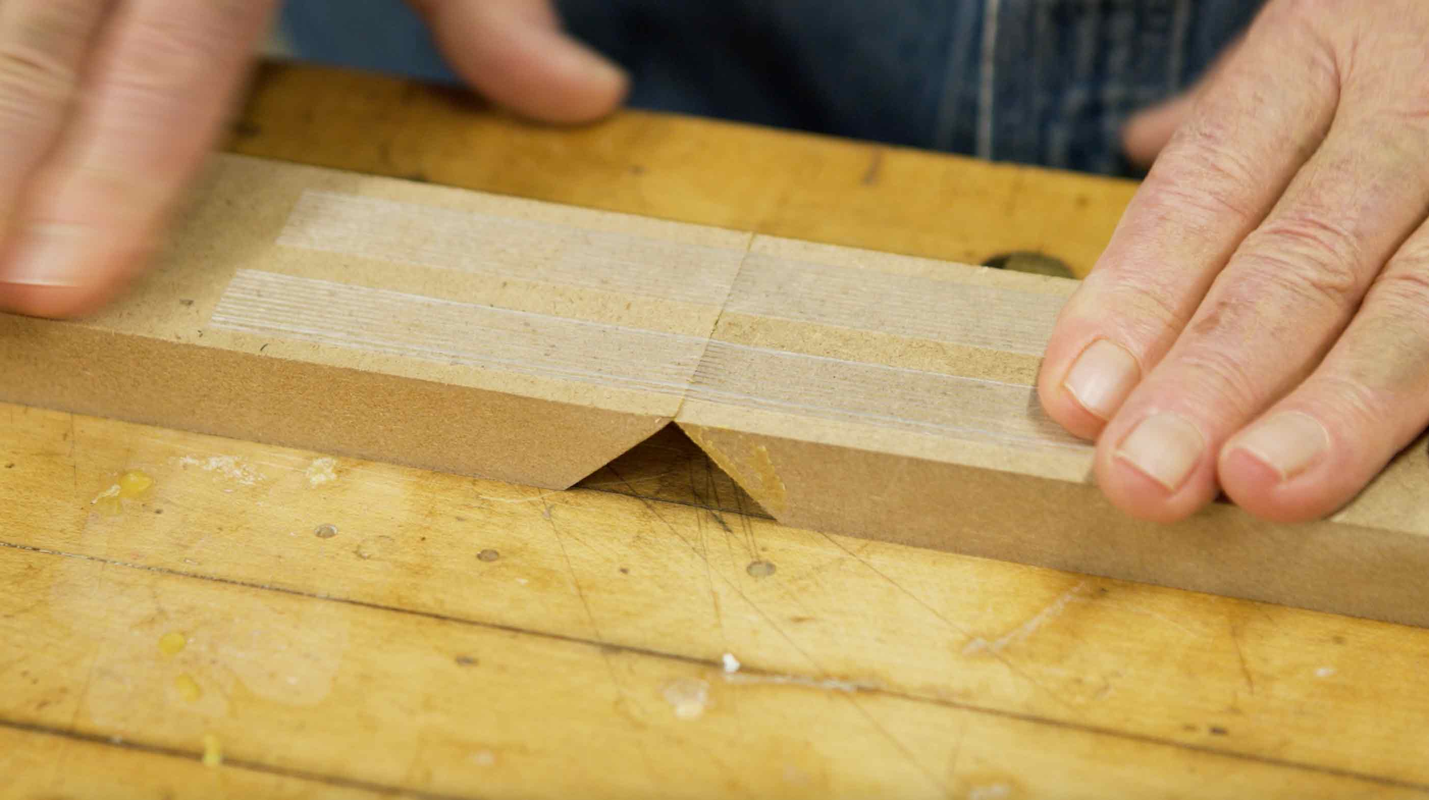Man puts filament tape across wood