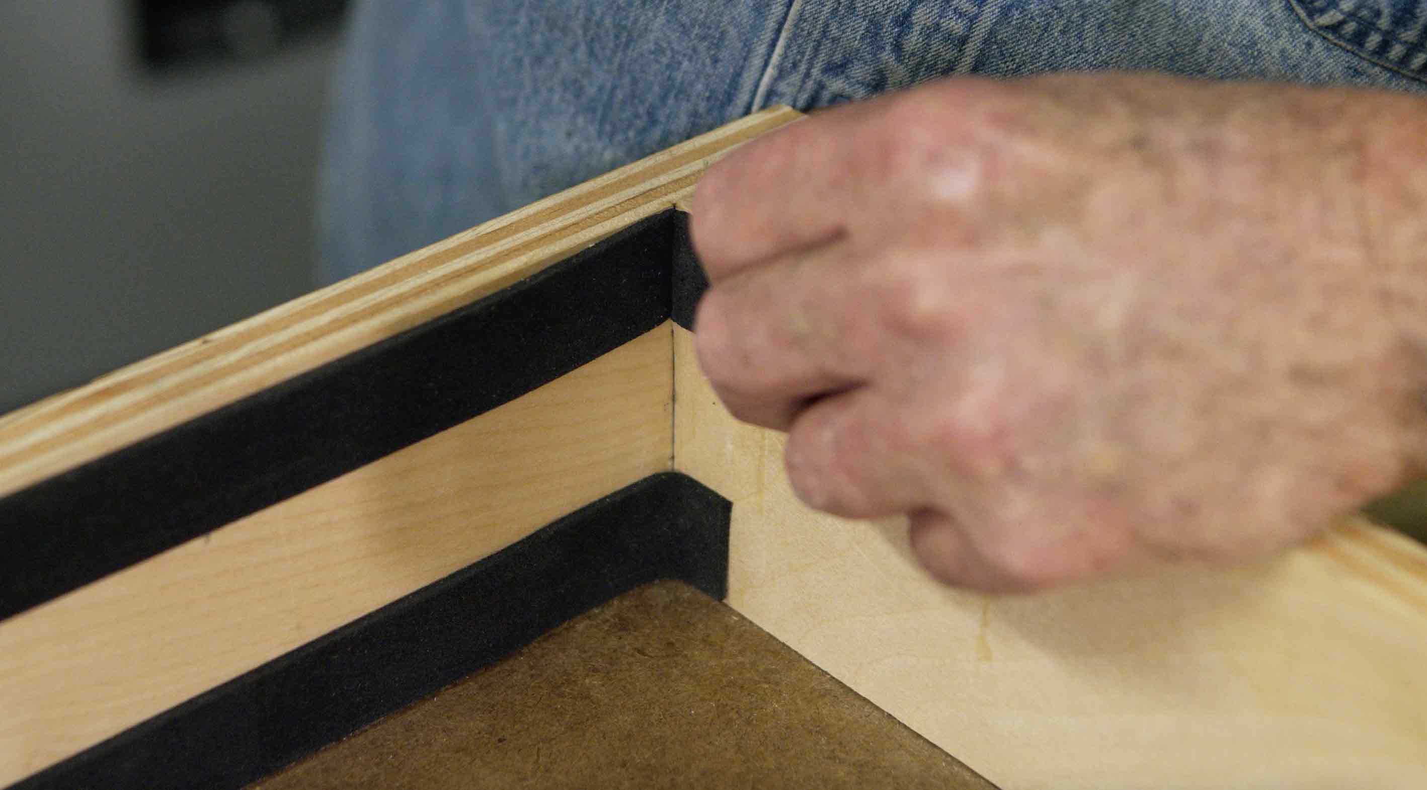 Man puts weather stripping inside drawer
