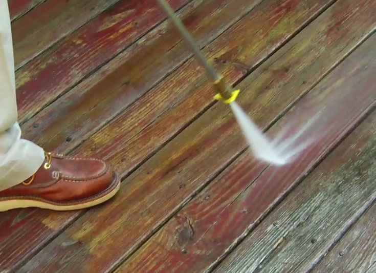 Man powerwashing deck 