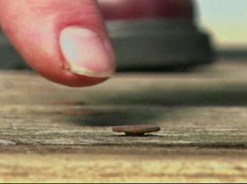 A protruding deck nail in a wooden deck
