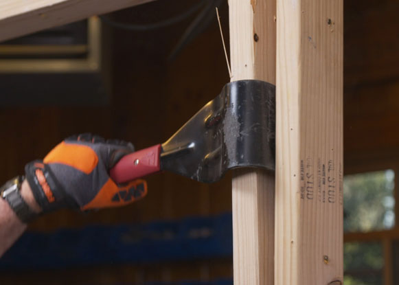 Man pries wooden framing apart 