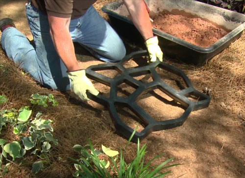 Placing the Quikrete Walmaker mold onto the bare ground