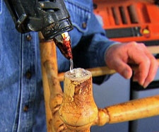 Glue gun being used to fix wobbly chair leg